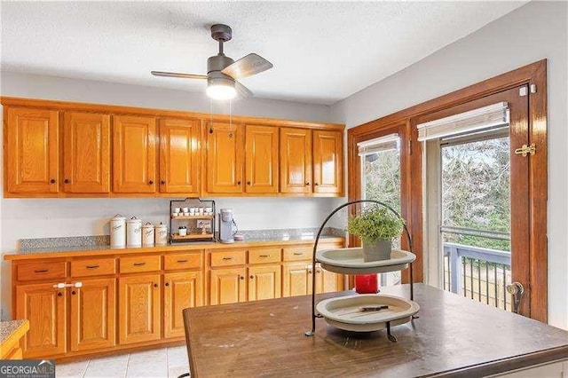 kitchen featuring a textured ceiling, ceiling fan, and light tile patterned floors