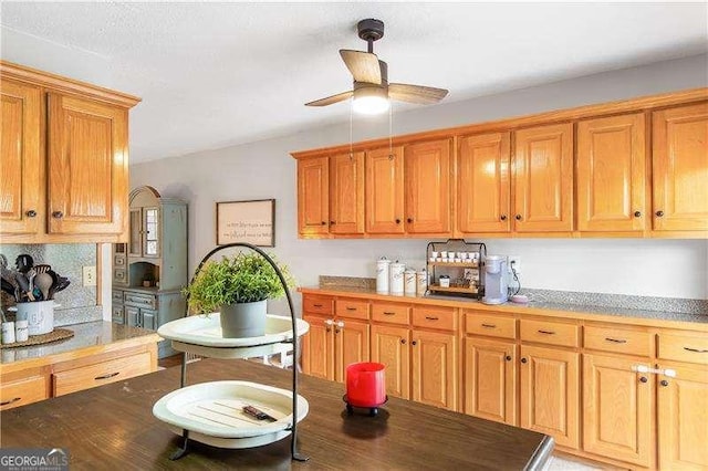 kitchen featuring ceiling fan and backsplash