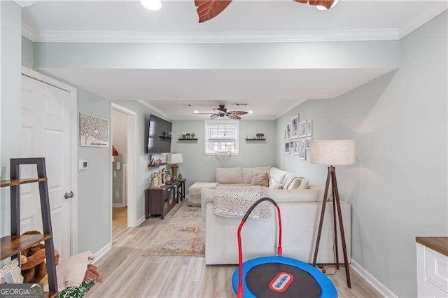 living room featuring ceiling fan, ornamental molding, and light hardwood / wood-style floors