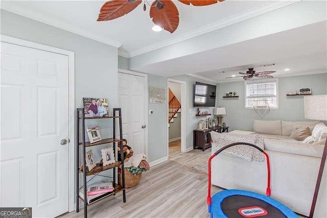 living room with light wood-type flooring and crown molding