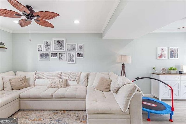 living room featuring ceiling fan, crown molding, and light hardwood / wood-style flooring