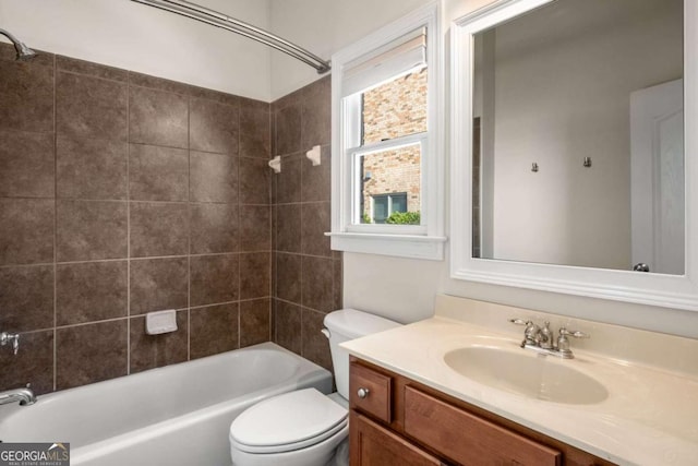 full bathroom with toilet, tiled shower / bath, and vanity