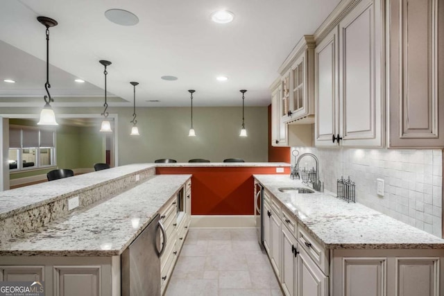 kitchen featuring kitchen peninsula, backsplash, pendant lighting, and sink