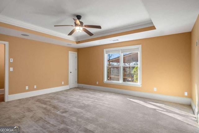 spare room featuring a raised ceiling, ornamental molding, and ceiling fan