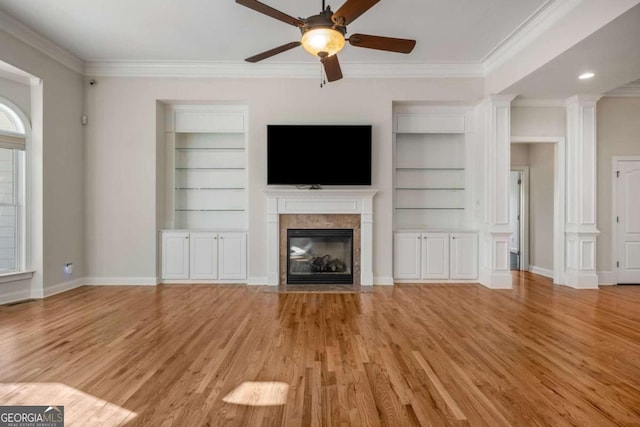 unfurnished living room with ornamental molding, ceiling fan, light hardwood / wood-style flooring, and built in shelves