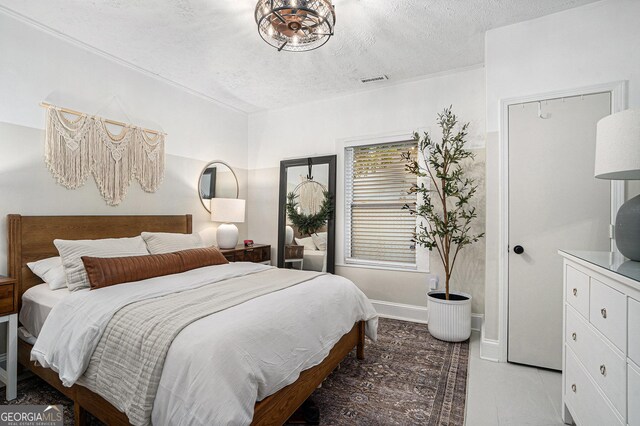 bedroom featuring a textured ceiling, stainless steel fridge, and ensuite bathroom