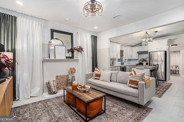 living room with vaulted ceiling and an inviting chandelier