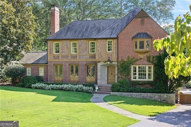 english style home with a front lawn