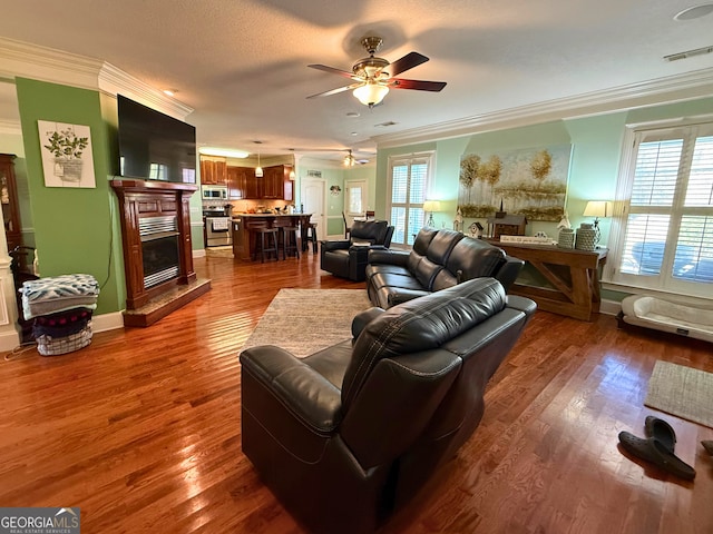 living room featuring ornamental molding, ceiling fan, and dark hardwood / wood-style floors