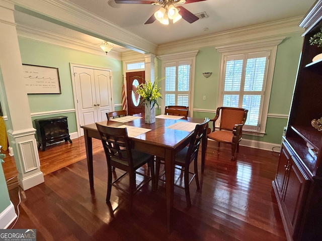 dining area with ceiling fan, dark wood-type flooring, crown molding, and ornate columns