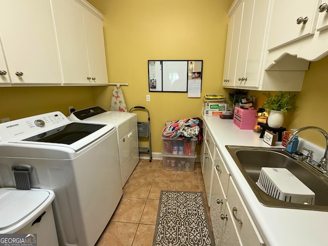 laundry room with sink, light tile patterned flooring, separate washer and dryer, and cabinets