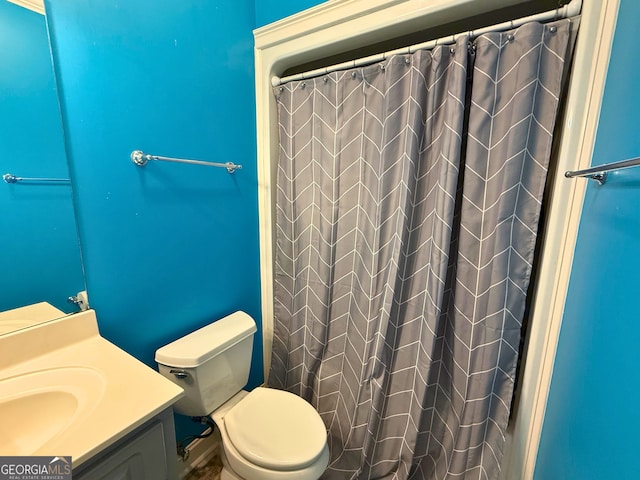 bathroom featuring toilet, vanity, and a shower with curtain