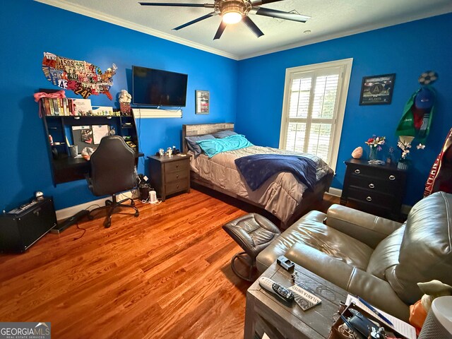 bedroom featuring ceiling fan, ornamental molding, and hardwood / wood-style flooring