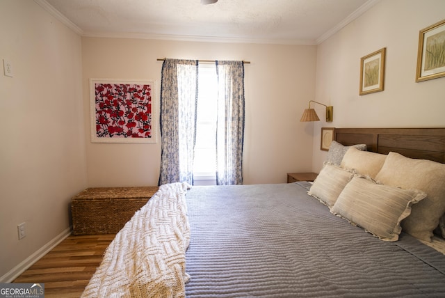 bedroom with a textured ceiling, ornamental molding, and hardwood / wood-style floors