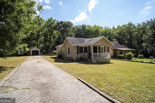 ranch-style home featuring a front yard, a garage, covered porch, and an outdoor structure