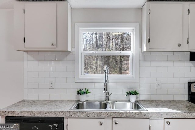 kitchen with dishwasher, decorative backsplash, white cabinets, and a sink