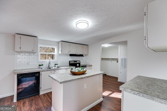 kitchen featuring tasteful backsplash, black dishwasher, dark wood-style floors, light countertops, and a sink