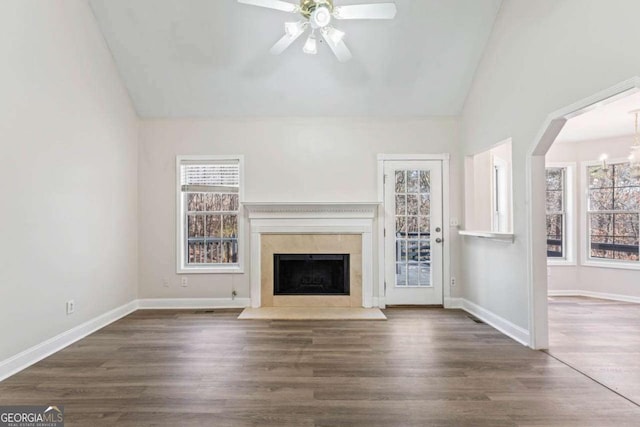 unfurnished living room with dark wood-type flooring, vaulted ceiling, and ceiling fan with notable chandelier