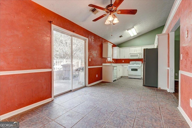 kitchen with white appliances, lofted ceiling, white cabinets, ceiling fan, and sink