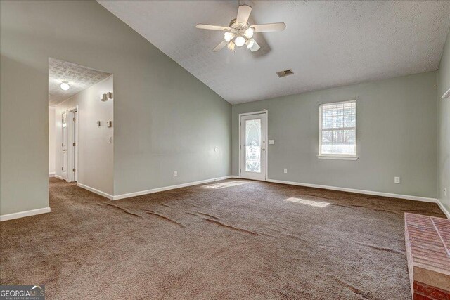 carpeted spare room featuring a textured ceiling, ceiling fan, and vaulted ceiling