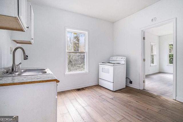 laundry room with light hardwood / wood-style floors and sink