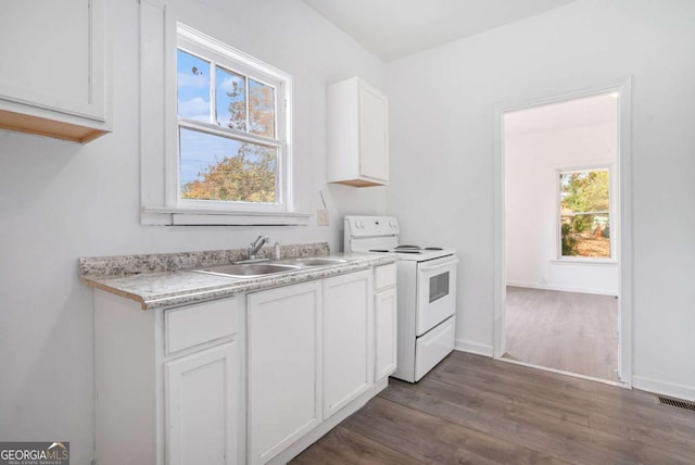 kitchen featuring sink, dark hardwood / wood-style flooring, white cabinetry, and white electric range