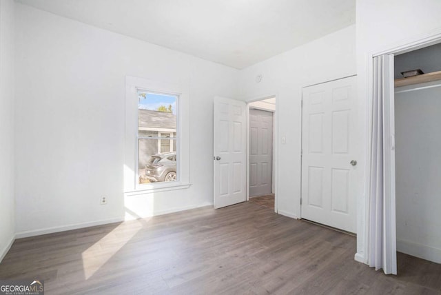 unfurnished bedroom with a closet and dark hardwood / wood-style floors