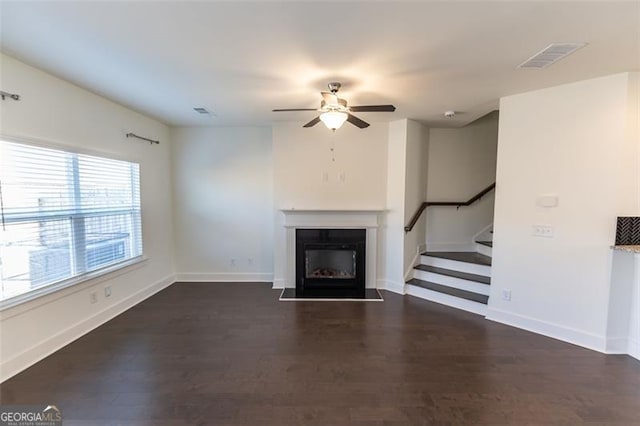 unfurnished living room with dark hardwood / wood-style flooring and ceiling fan