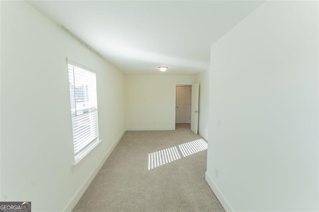 spare room featuring light colored carpet