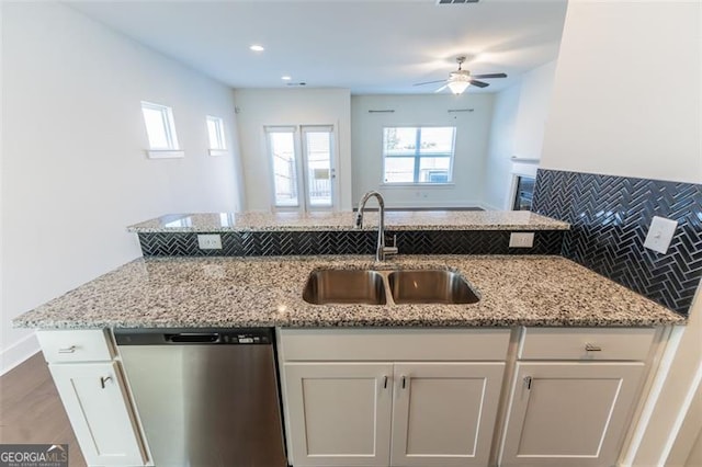 kitchen featuring dishwasher, ceiling fan, sink, white cabinetry, and backsplash