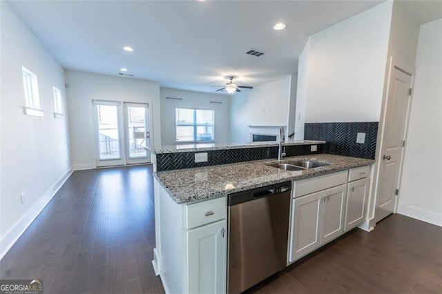 kitchen featuring light stone counters, stainless steel dishwasher, white cabinetry, ceiling fan, and sink