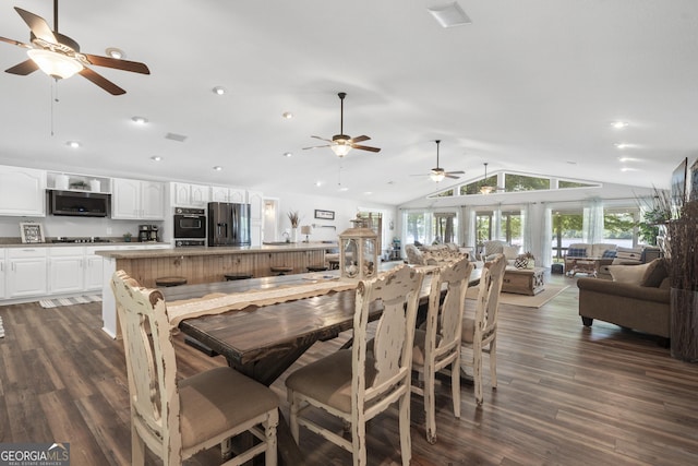 dining area featuring vaulted ceiling and dark hardwood / wood-style floors