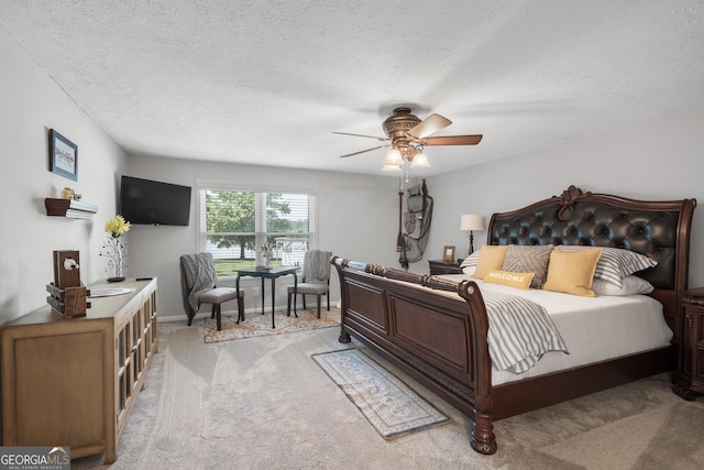 bedroom featuring ceiling fan, light carpet, and a textured ceiling