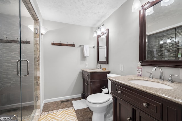 bathroom with a textured ceiling, walk in shower, vanity, and toilet