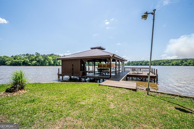 view of dock featuring a lawn and a water view