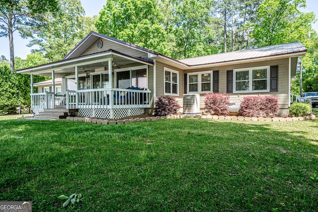 single story home featuring covered porch, central air condition unit, and a front yard