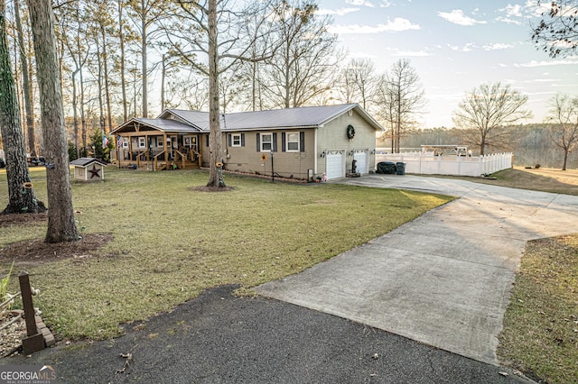 ranch-style house with covered porch, a front yard, and a garage