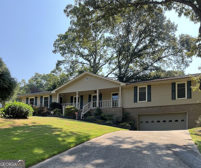 ranch-style home featuring a porch, a front lawn, and a garage