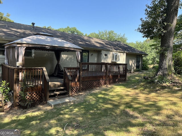 rear view of house featuring a yard, a wooden deck, and a gazebo