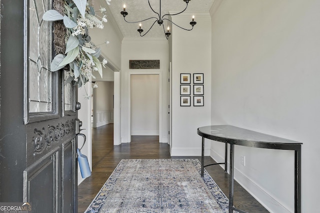 entryway with baseboards, ornamental molding, dark wood finished floors, and a notable chandelier