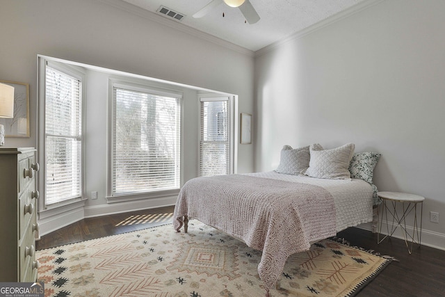 bedroom featuring baseboards, visible vents, ceiling fan, ornamental molding, and wood finished floors