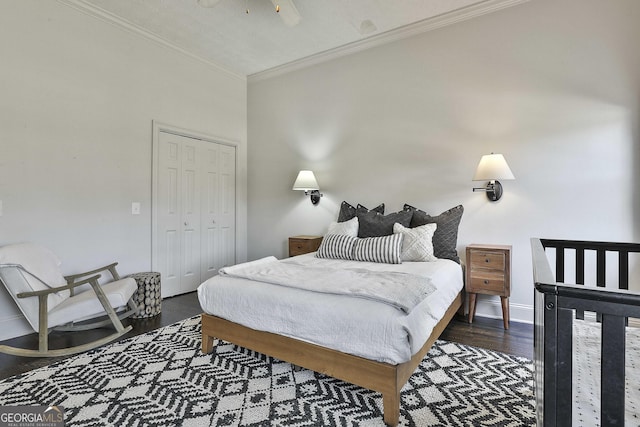 bedroom featuring a closet, crown molding, baseboards, and wood finished floors