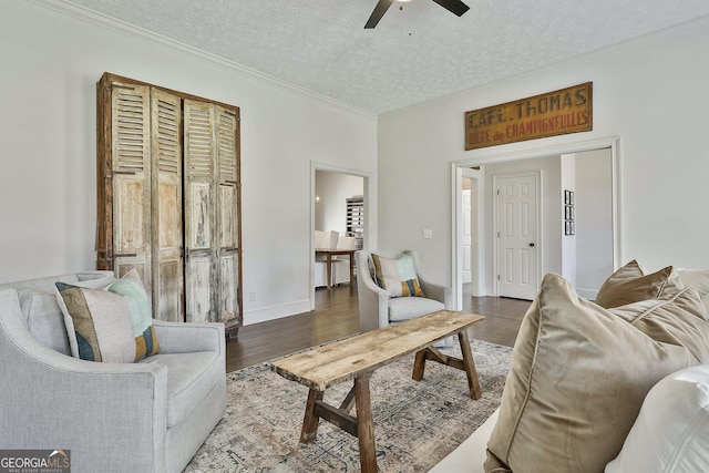 living room featuring crown molding, a textured ceiling, ceiling fan, and wood finished floors