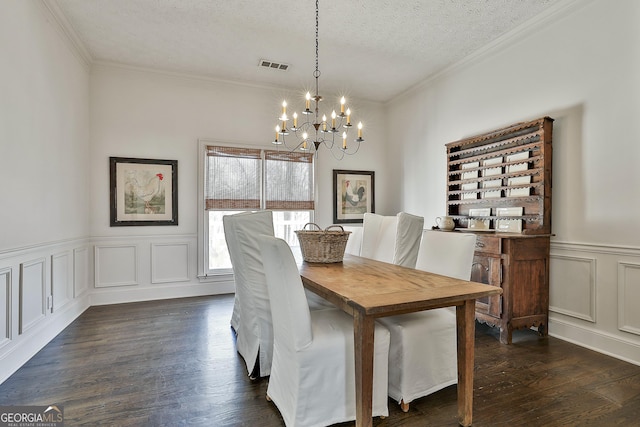 dining space featuring crown molding, visible vents, dark wood-type flooring, a textured ceiling, and a chandelier