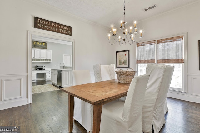 dining room with dark wood-type flooring, visible vents, crown molding, and a textured ceiling