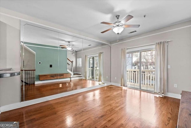 exercise area with ceiling fan, a wealth of natural light, and hardwood / wood-style floors