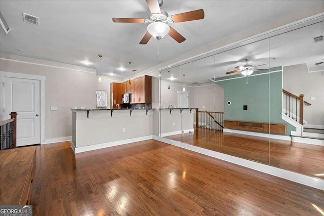 unfurnished living room with hardwood / wood-style floors and ceiling fan