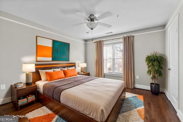 bedroom with dark hardwood / wood-style flooring and ceiling fan