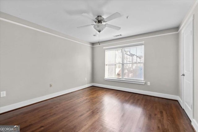 spare room featuring dark hardwood / wood-style flooring and ceiling fan