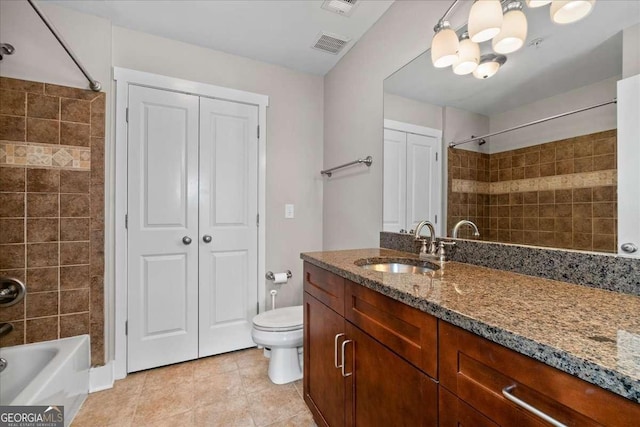 full bathroom featuring tile patterned flooring, tiled shower / bath combo, vanity, and toilet